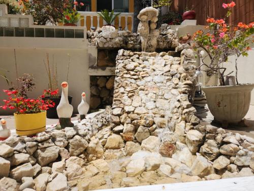 a stone wall with some vases and flowers at Sadie's Bed and Breakfast / Hotel in Tijuana