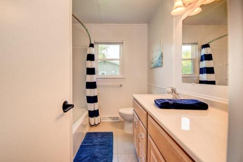 uma casa de banho com um lavatório, um WC e um espelho. em Boji Waterfront Retreat - Millers Bay Canals em Milford