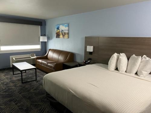 une chambre d'hôtel avec un lit et un canapé dans l'établissement GARDEN INN & Suites, à Hebbronville