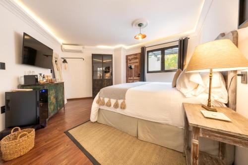 1 dormitorio con 1 cama y 1 mesa con lámpara en Orchid House Polanco, en Ciudad de México