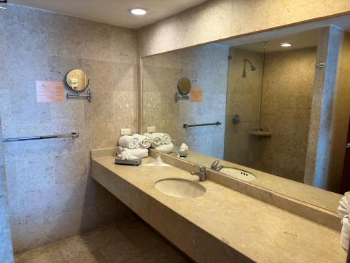 a bathroom with a sink and a mirror at Hotel Quijote Inn in Mazatlán