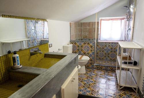 a bathroom with a sink and a toilet at Villa Zagara Garden Spectacular Sea View in Taormina in Taormina