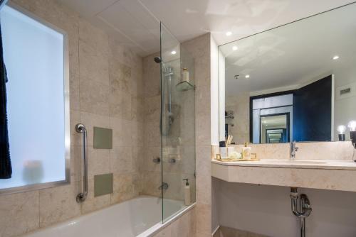 uma casa de banho com uma banheira, um lavatório e um chuveiro em Designer Suites - Versace On View em Gold Coast