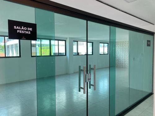an empty hallway with glass doors in a building at Apartamento Sofisticado em frente ao Shopping Caruaru in Caruaru