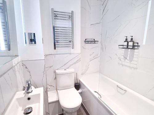 Baño blanco con aseo y lavamanos en Seagull Place - The Lanes Brighton City Centre en Brighton & Hove