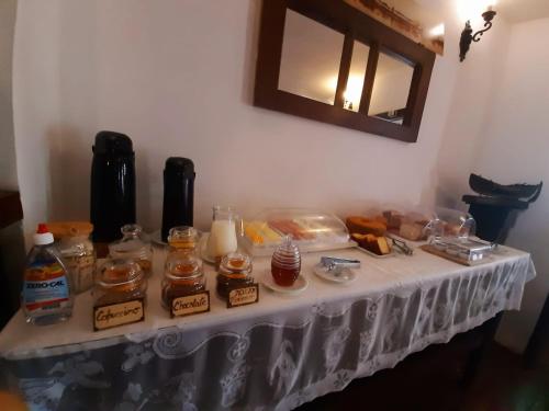 einen Tisch mit einem weißen Tischtuch mit Essen drauf in der Unterkunft Pousada Villa de Cananea in Cananéia