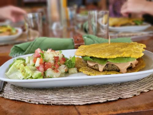 a plate with a sandwich and salad on a table at Casa Cayuco Eco-Adventure Lodge in Bocas del Toro