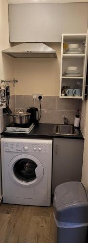 a kitchen with a washing machine and a sink at Lovely studio flat in Reading