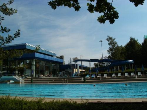 a swimming pool in front of a building at Tannhäuser Ferienwohnung in Bad Dürrheim