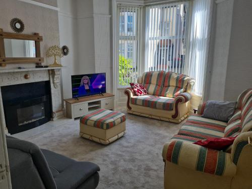 a living room with couches and a flat screen tv at Lawnswood Apartments in Blackpool