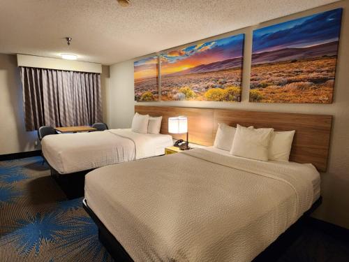 a hotel room with two beds and a painting on the wall at Days Inn by Wyndham Tucumcari in Tucumcari