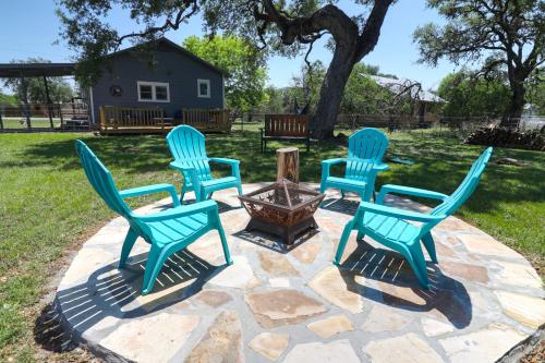 four chairs around a fire pit in a yard at Bandera Bungalow - River, Downtown, Peaceful fenced corner lot! King bed! in Bandera