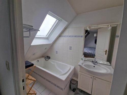 une salle de bain avec un lavabo et une baignoire dans l'établissement Bel appartement cosy et lumineux en duplex, à Granville