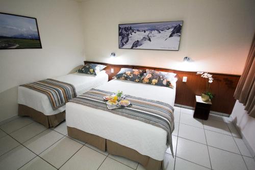 a hotel room with two beds in a room at Aguas do Iguaçu Hotel Centro in Foz do Iguaçu