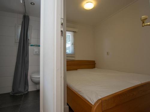 Dormitorio pequeño con cama y aseo en Boszicht, en Heeswijk-Dinther