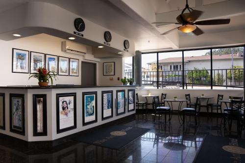 a dining room with tables and chairs and windows at Art Hotel Laguna Beach in Laguna Beach