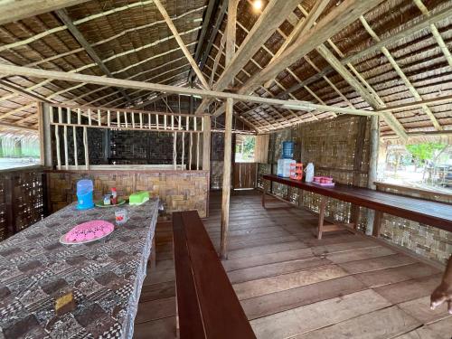 a room with a table and benches in a building at Kri guest homestay in Rancakole