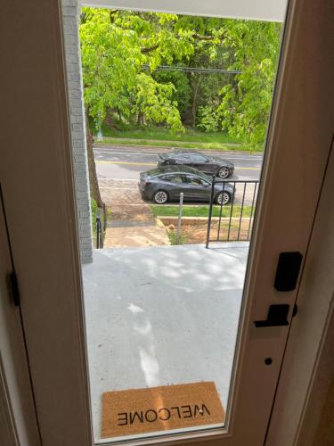 una porta che si apre su un vialetto con un'auto in un parcheggio di Rivera Properties a Washington