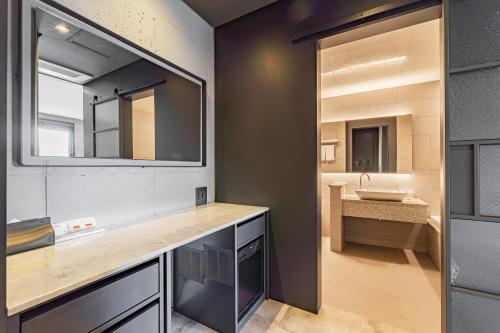 a bathroom with a sink and a mirror at The Hong C Hotel in Gangneung