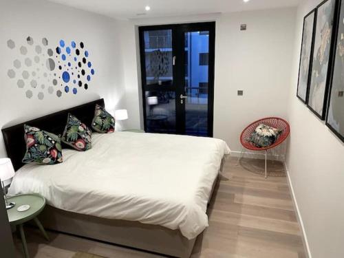 a bedroom with a large white bed and a glass door at Royal Sands Ramsgate - direct beach access in Ramsgate