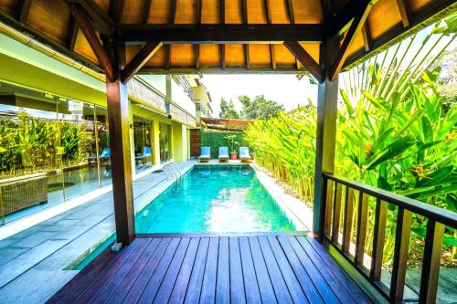 an outdoor deck with a swimming pool in a house at Villa LOGAN - KUTA - 5 Bedroom - 3 Bathroom Villa - Great Location in Kuta