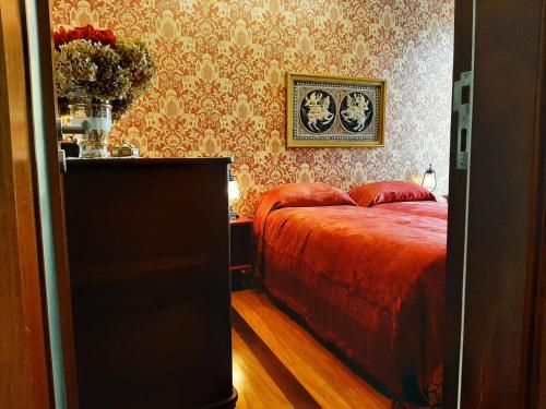 Schlafzimmer mit einem Bett mit einer roten Tagesdecke in der Unterkunft Treasure Roses Private Pool Villa in Armamar