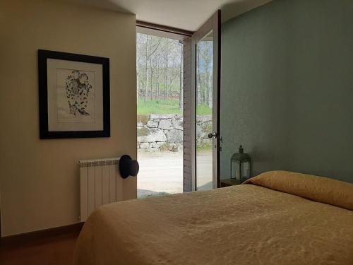 Schlafzimmer mit einem Bett und einer Glasschiebetür in der Unterkunft Treasure Roses Private Pool Villa in Armamar
