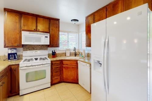 a kitchen with white appliances and wooden cabinets at Rocky Pines in Twin Peaks
