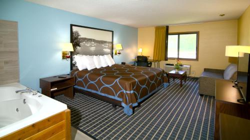 a hotel room with a bed and a bathroom at Super 8 by Wyndham Red Wing in Red Wing