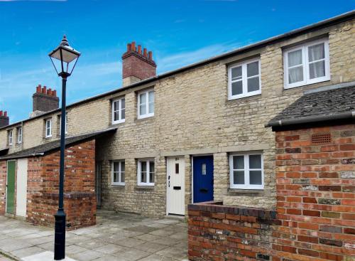 a brick building with a blue door and a street light at Converted Railway Cottage in Swindon
