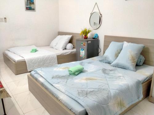 1 Schlafzimmer mit 2 Betten und einem Spiegel in der Unterkunft Happy Sunshine 1 in Ho-Chi-Minh-Stadt