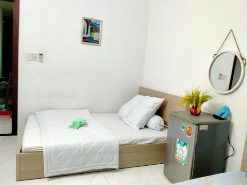 ein kleines Schlafzimmer mit einem Bett und einem Spiegel in der Unterkunft Happy Sunshine 1 in Ho-Chi-Minh-Stadt