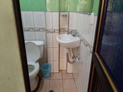 a small bathroom with a toilet and a sink at Residencial RM in Puerto Francisco de Orellana