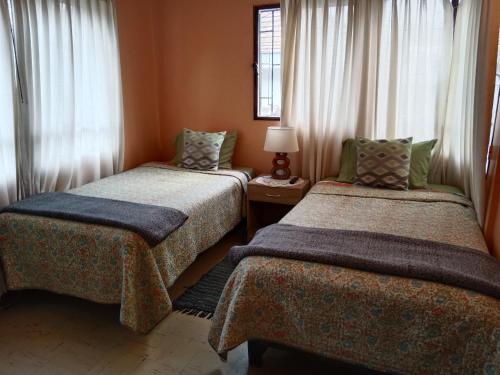 a room with two beds and a window at Tu Jardín Secreto in La Serena