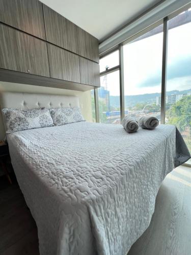 sypialnia z białym łóżkiem i 2 ręcznikami w obiekcie Moderno y Céntrico Aparta-Estudio w mieście Tegucigalpa