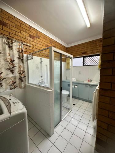 a bathroom with a shower and a toilet and a sink at Cosy holiday entire unit 1 in Caloundra West