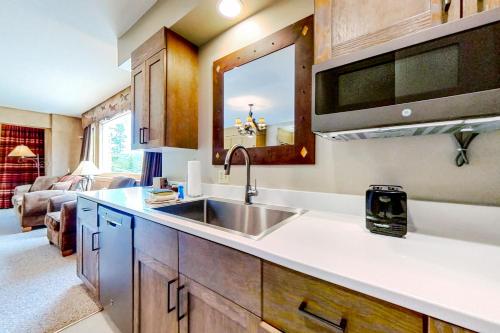 a kitchen with a sink and a living room at Shoshone 1905 in Big Sky