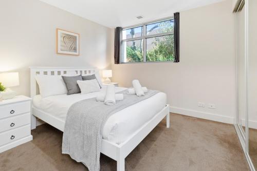 a white bedroom with a white bed and a window at Salt Five Apartment Sorrento - Main Street Location in Sorrento