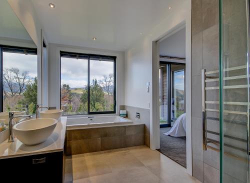 a bathroom with a tub and a large window at Terrace Lodge by Sotheby's Luxury Rental Homes in Queenstown