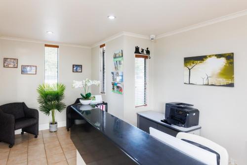 a living room with a desk and a chair at Camelot Motor Lodge and Conference Centre in Palmerston North