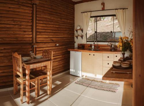 uma cozinha com mesa e cadeiras num quarto em Chalé do Vale locação de temporada em Águas de Lindóia