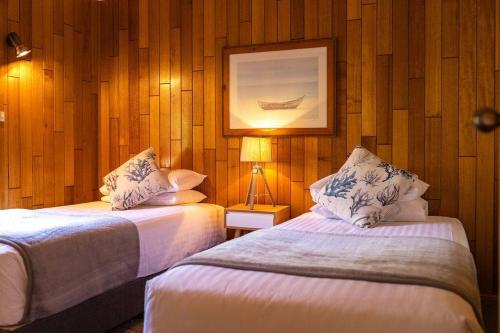 ein Schlafzimmer mit 2 Betten und einem Bild an der Wand in der Unterkunft Beach Break - Diamond Island in Bicheno