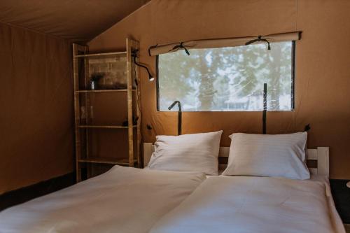 para łóżek w pokoju z oknem w obiekcie Sioglamping in Siocamping w Siófoku