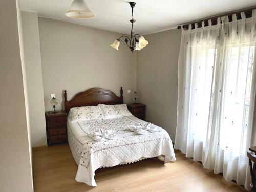 1 dormitorio con cama y ventana grande en Casa Rural Valito, en Armallones