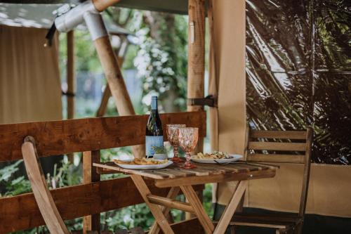 a table with a bottle of wine and plates of food at Sioglamping in Siocamping in Siófok