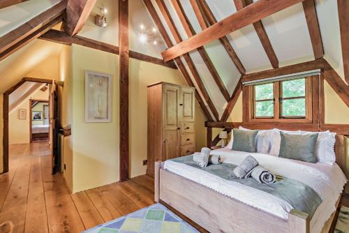 a bedroom with a large bed in a room with wooden ceilings at The Cottage, Beautiful New Forest 5 Bedroom Thatched Cottage in Breamore