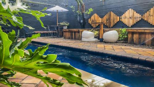 a pool in a backyard with a table and an umbrella at Fardo Hotel Boutique en Ibague - Zona G - Recepción Digital 24H in Ibagué