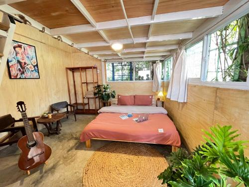 a bedroom with a bed and a guitar in it at The Burrow Dalat in Da Thanh