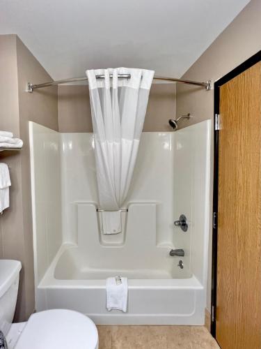 a bathroom with a bathtub with a shower curtain at Quality Inn & Suites Wisconsin Dells Downtown - Waterparks Area in Wisconsin Dells