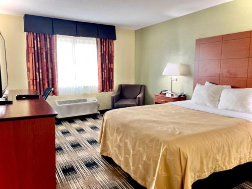 a hotel room with a bed and a chair at Quality Inn & Suites Wisconsin Dells Downtown - Waterparks Area in Wisconsin Dells